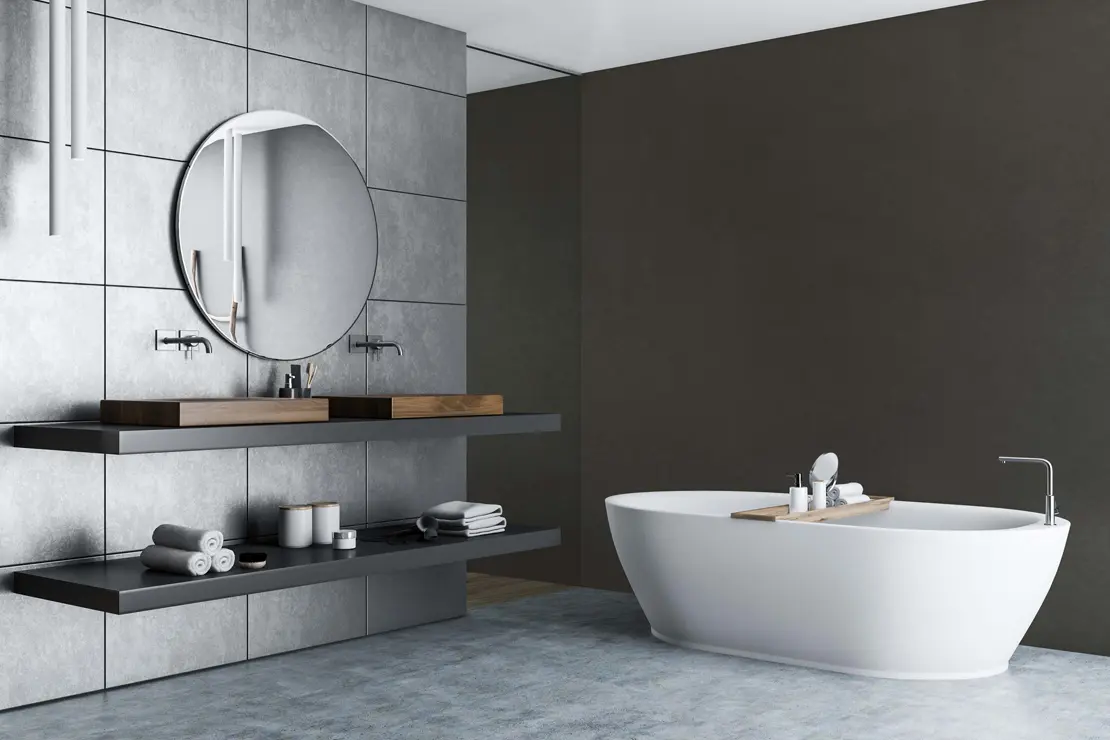 Baño con paredes de microcemento de tonalidad gris profunda.